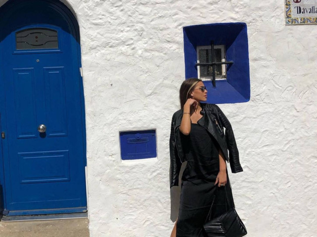 Girl in front of white and blue Mediterranean house