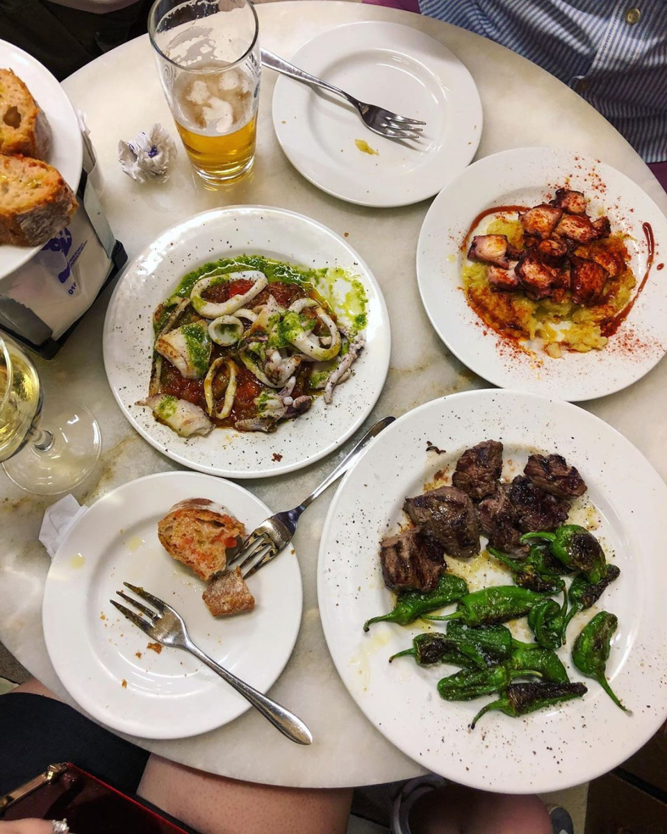 Image of table with three tapas plates and beers.