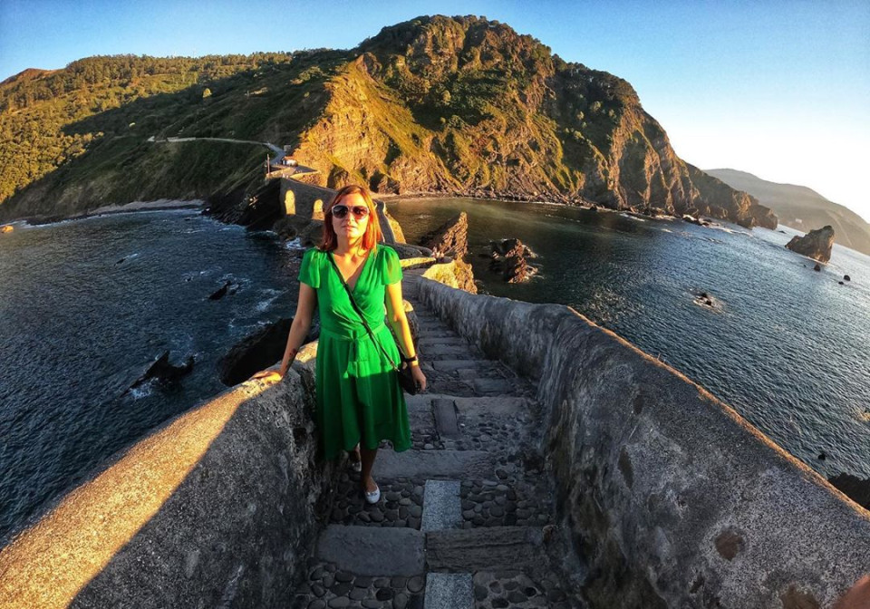 girl in green dress in front of San Juan de Gaztelugatxe.